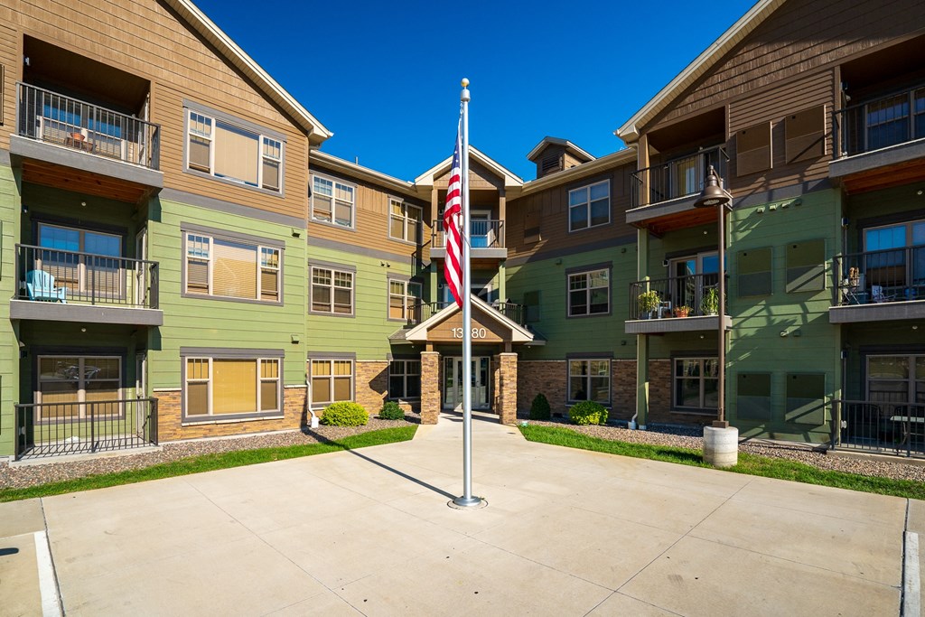 an flag on a pole in front of an apartment building