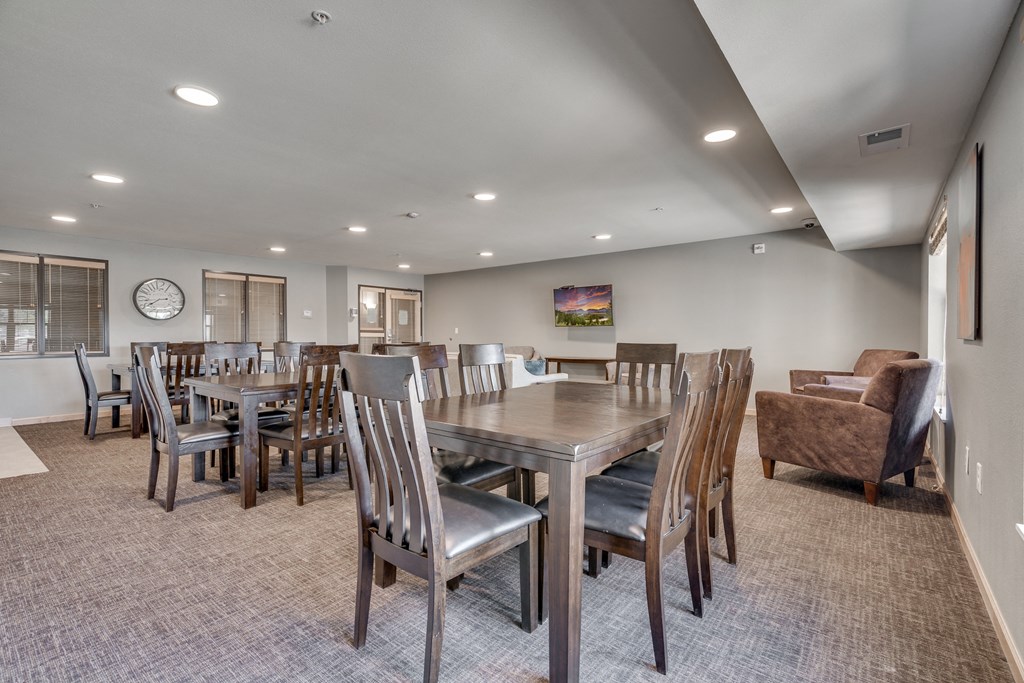 a community room with a large dining table and chairs