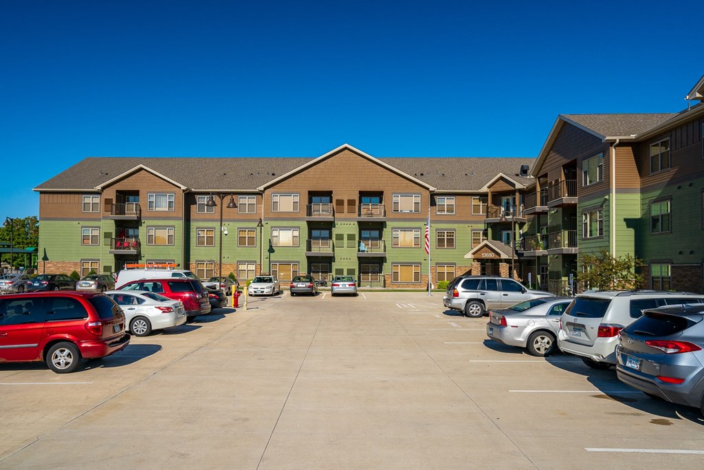 a parking lot with cars in front of an apartment building