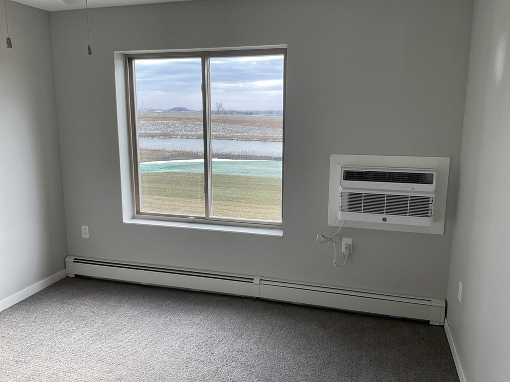 an empty room with a window and an air conditioner