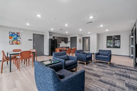 A modern living room with blue chairs and a wooden table.