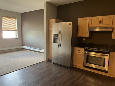 A kitchen with a refrigerator, oven, and cabinets.