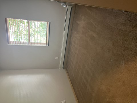 A room with a window and a wall with a textured surface.