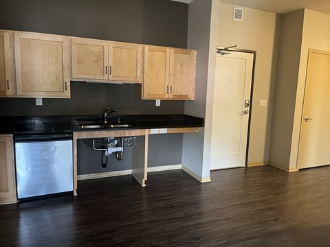 A kitchen with wooden cabinets and a black countertop.