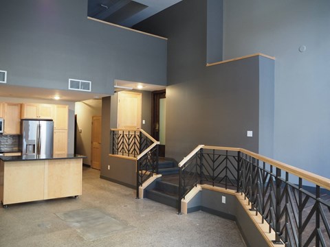 A staircase with a black railing and a wooden handrail.