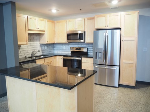 a kitchen with stainless steel appliances and black counter tops