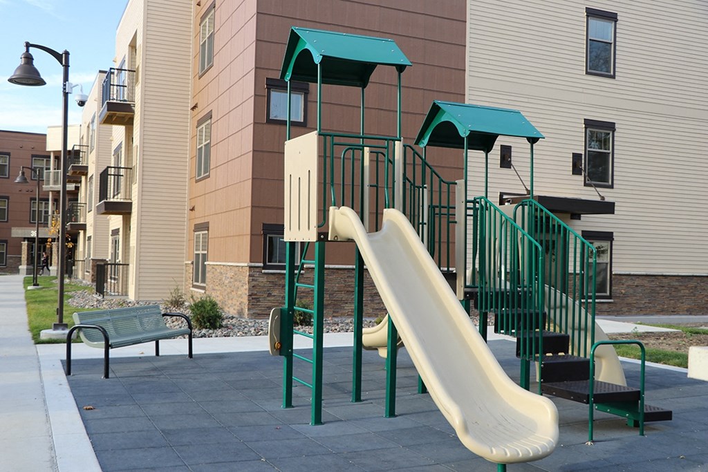 a playground with a slide in front of a building