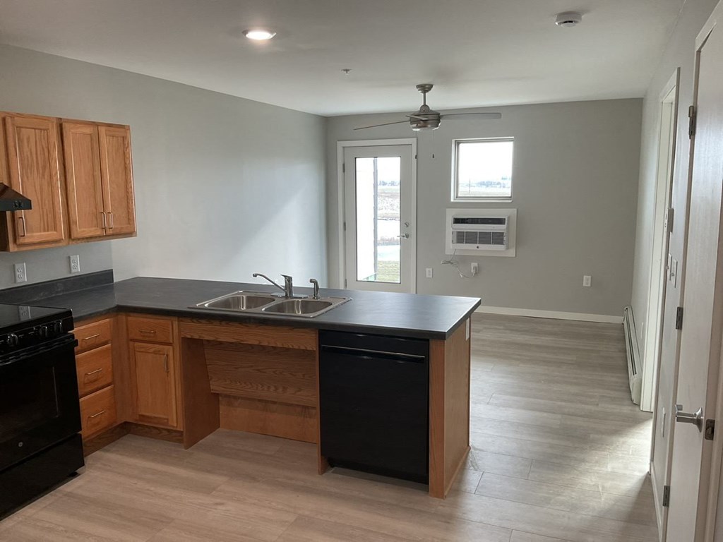 an empty kitchen with wooden cabinets and a sink