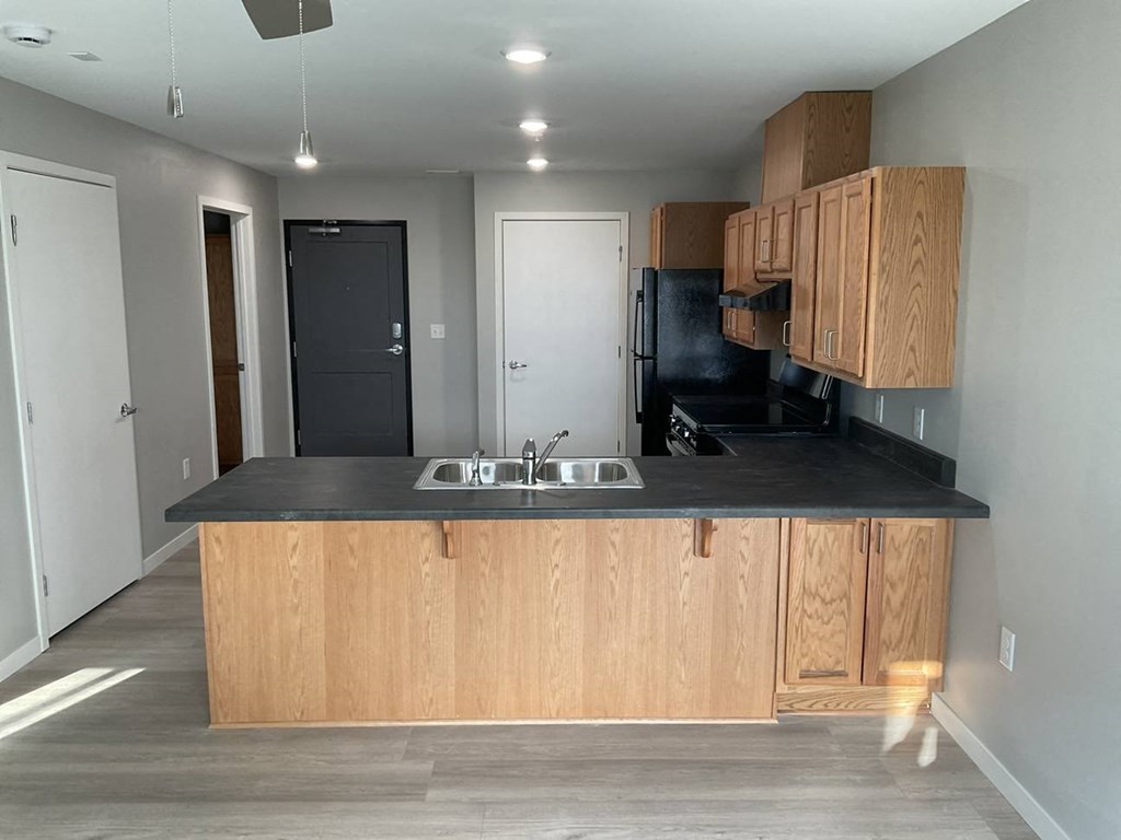 a kitchen with wooden cabinets and a black counter top