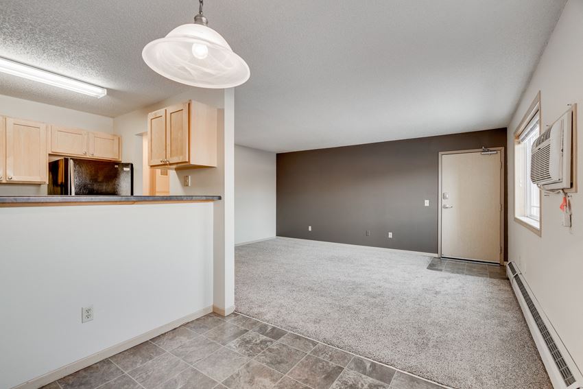 an empty kitchen and living room with a door to the bedroom