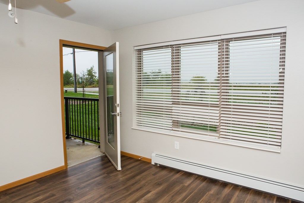 A room with a sliding glass door leading to a balcony.