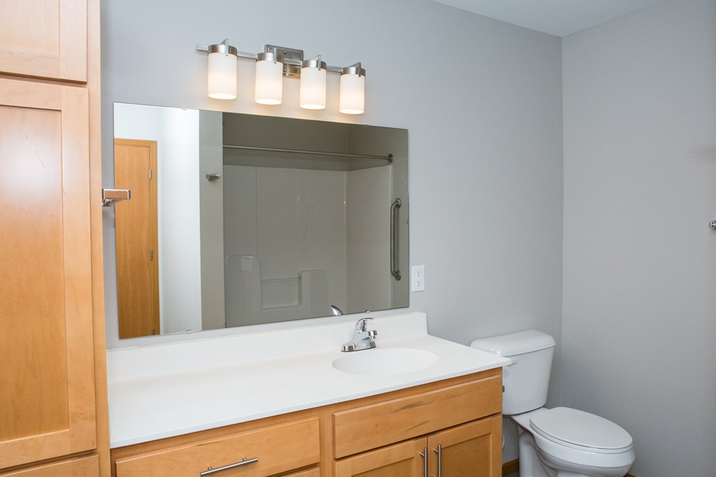 A bathroom with a white sink and a mirror above it.