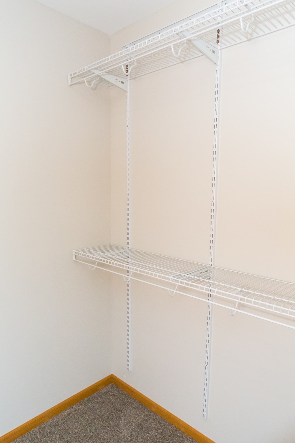 Empty white shelves in a corner of a room.