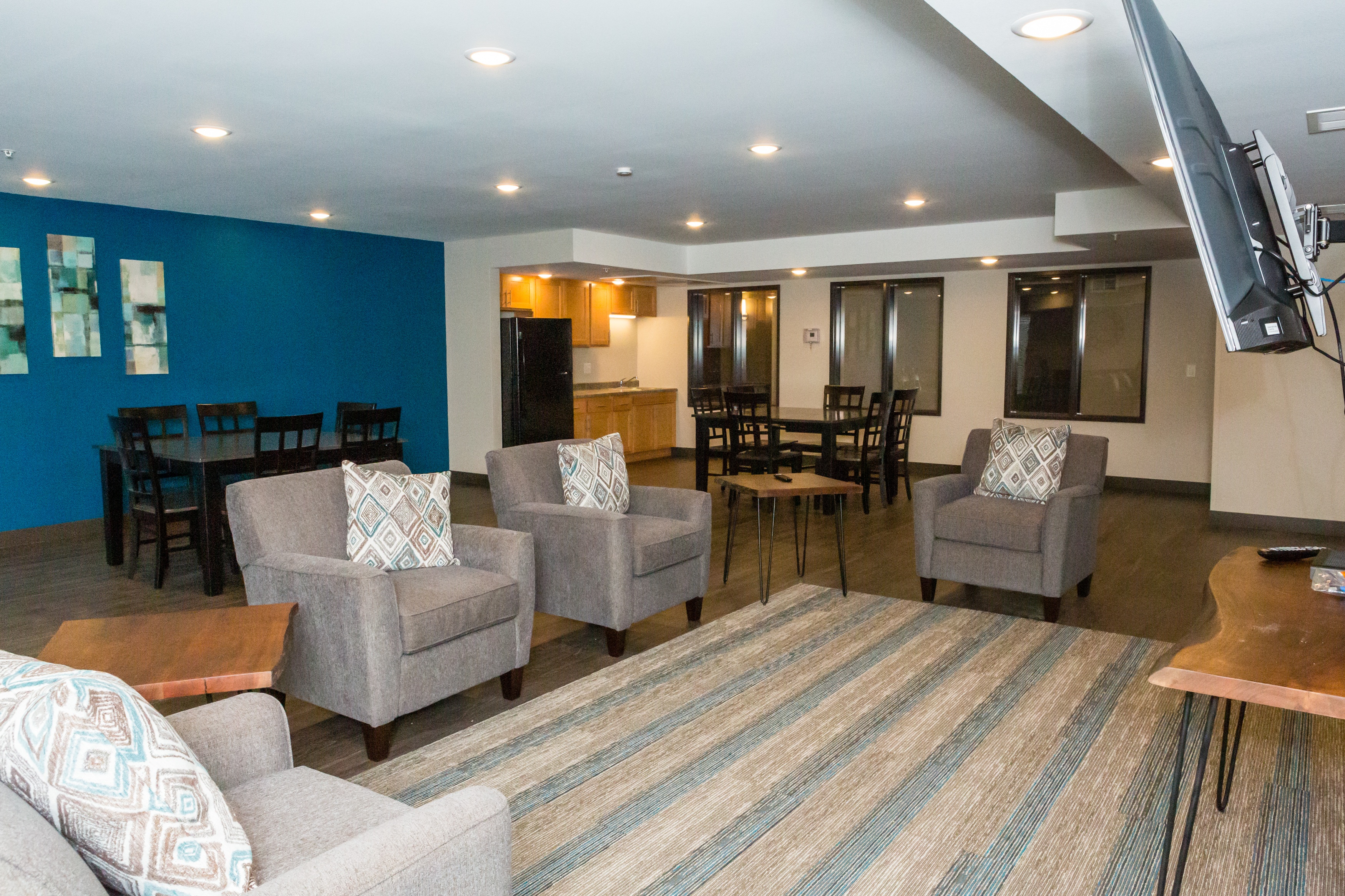 A living room with grey chairs and a striped rug.