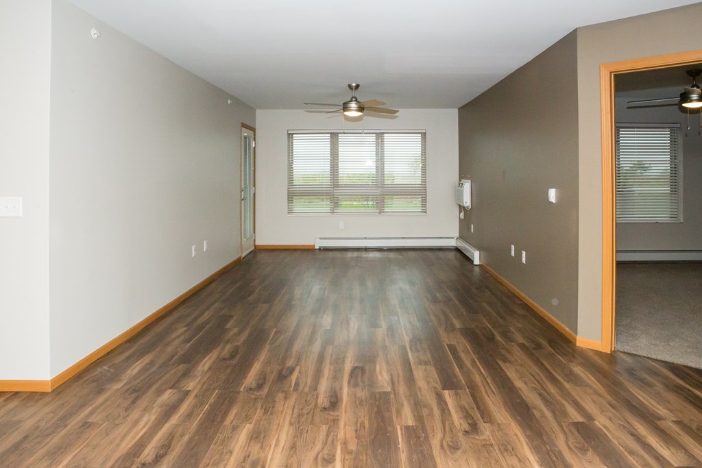 A room with wooden flooring and a ceiling fan.