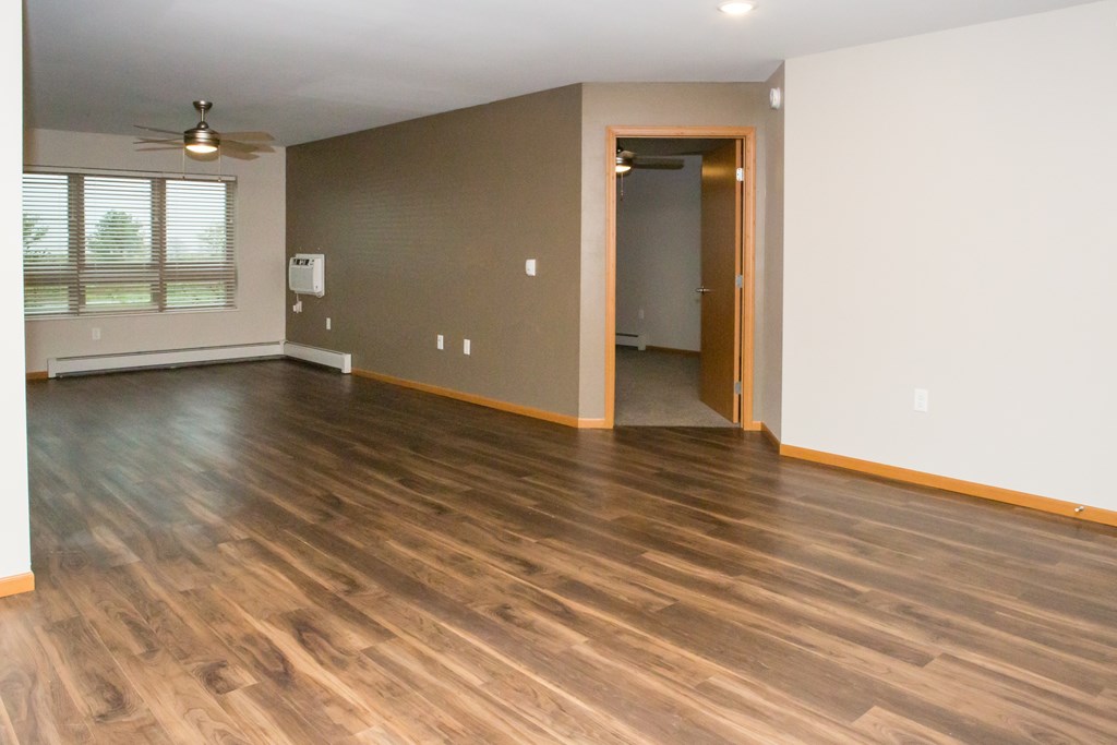 A room with wooden flooring and a ceiling fan.