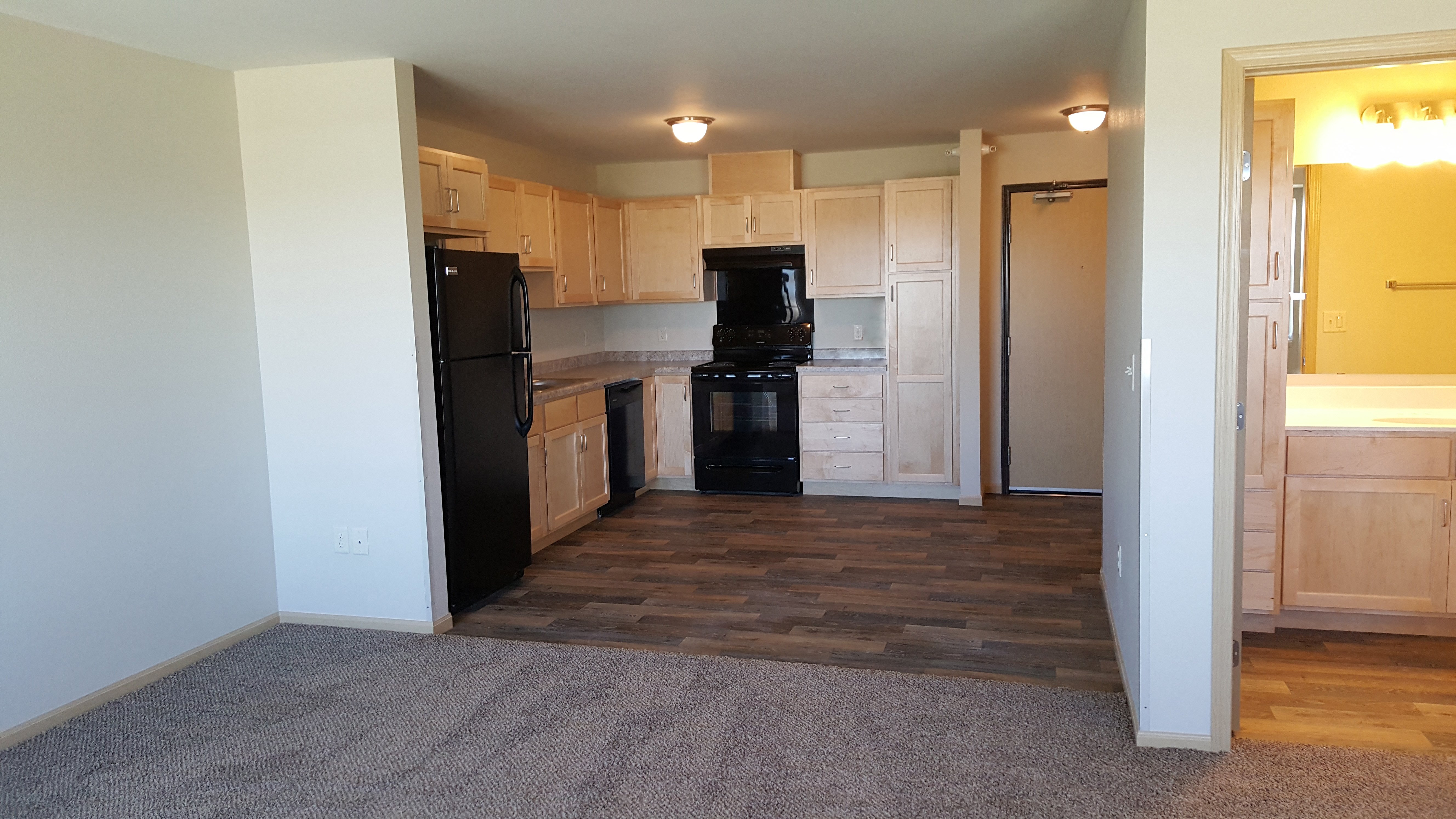 A kitchen with black appliances and wooden cabinets.