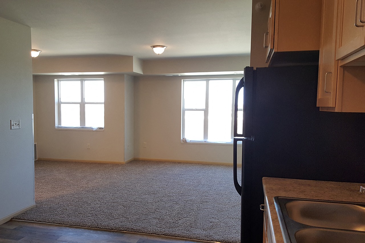 A kitchen area with a sink and a refrigerator.