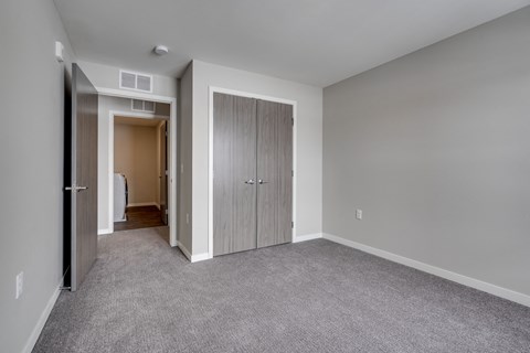 a bedroom with a closet and a door to a hallway