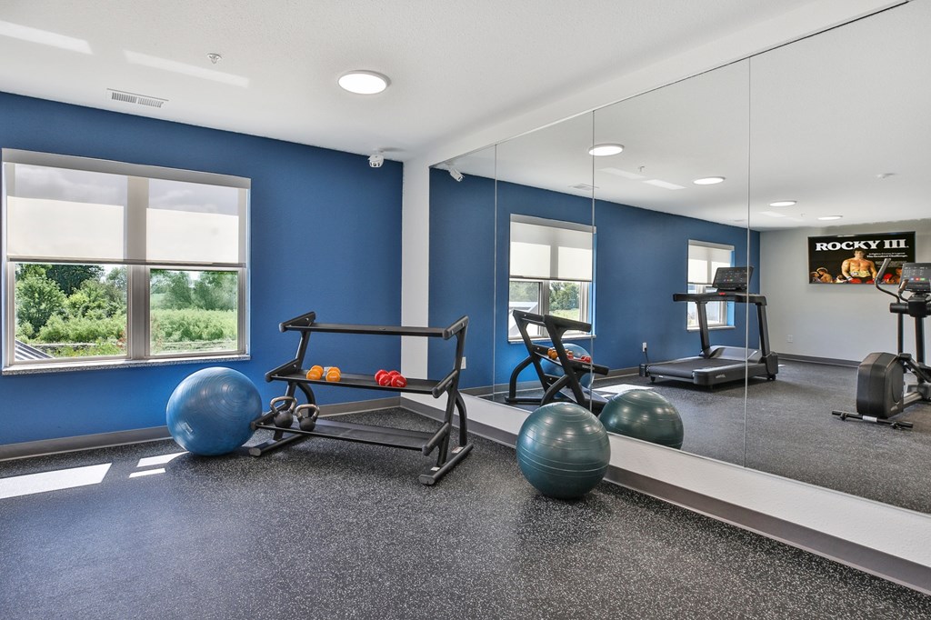 A gym with blue walls and a mirror on the wall.
