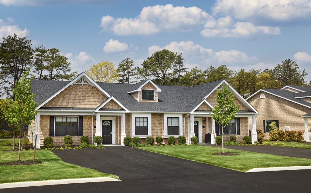 a house with a driveway and a lawn in front of it