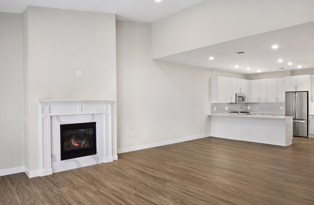 a living room with a fireplace and a kitchen