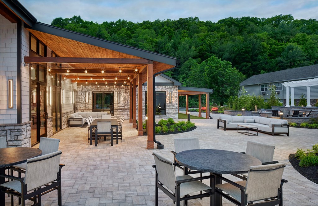 a patio with tables and chairs and a pavilion with lights at Heritage Oyster Bay, East Norwich, NY