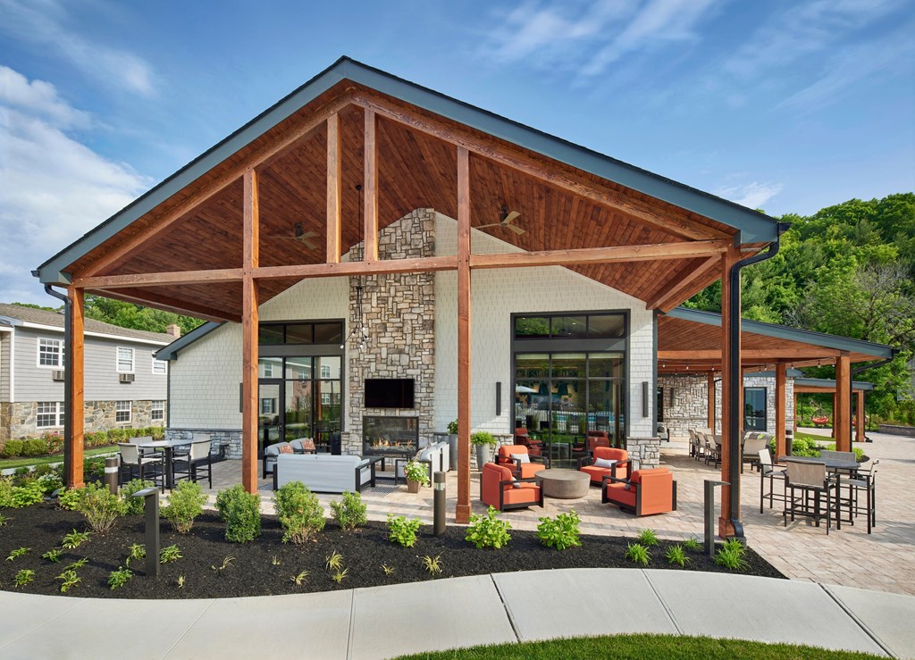 a patio with furniture and a fireplace at the Clubhouse atHeritage Oyster Bay, East Norwich, NY