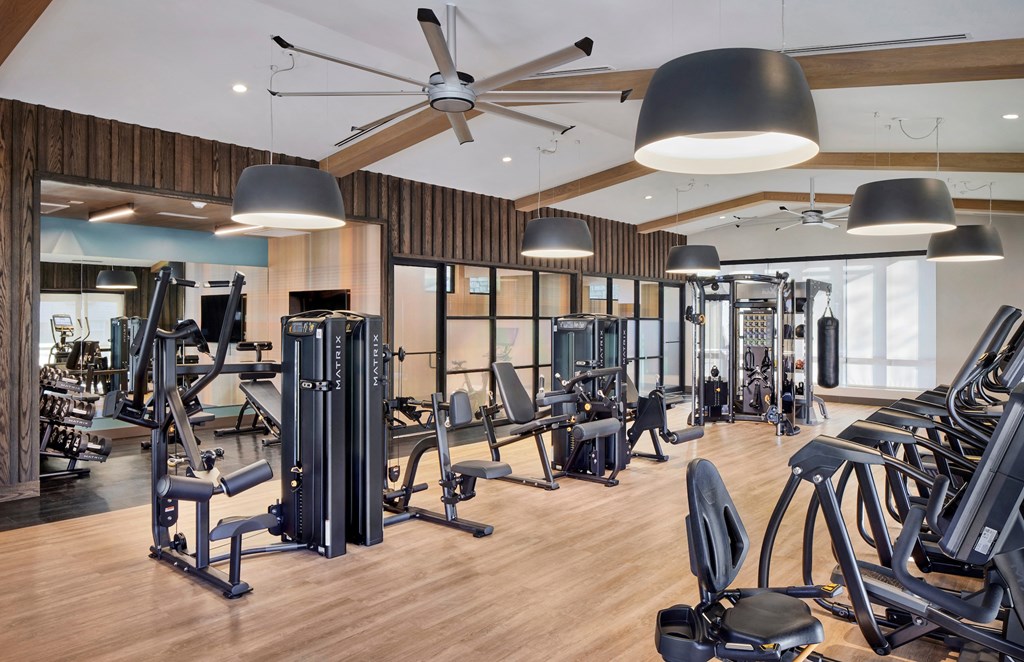a gym with cardio machines and a ceiling fan at Heritage Oyster Bay, East Norwich, NY