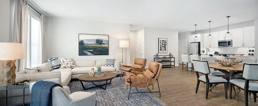 a living and dining room area with a white couch and chairs and a dining table with chairs