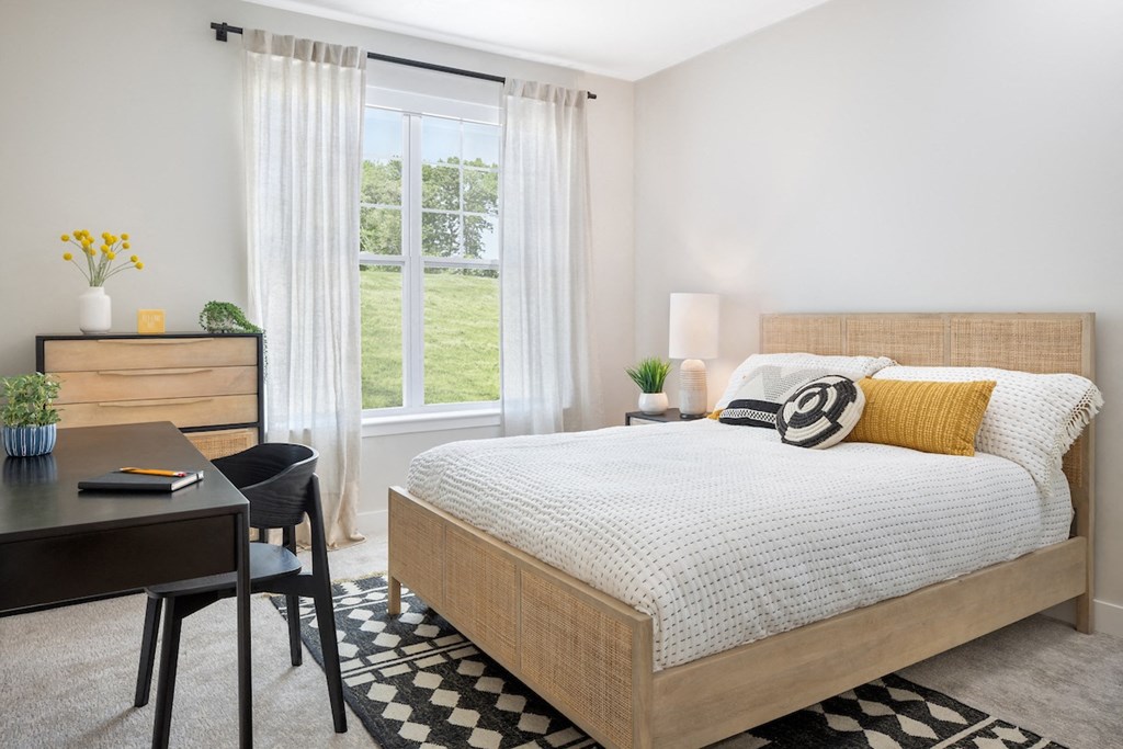 a bedroom with a bed and desk in a 555 waverly unit
