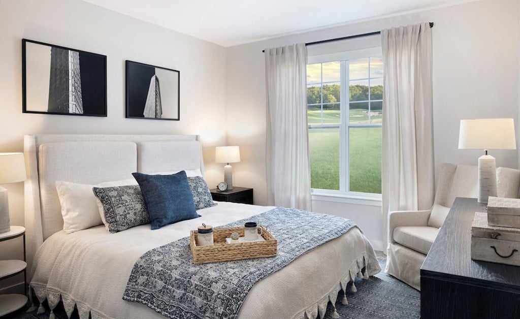 a bedroom with a large bed and a window with a view of a golf course