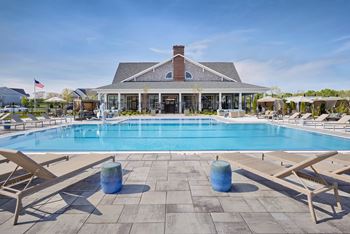 A poolside area with sun loungers and a building in the background.