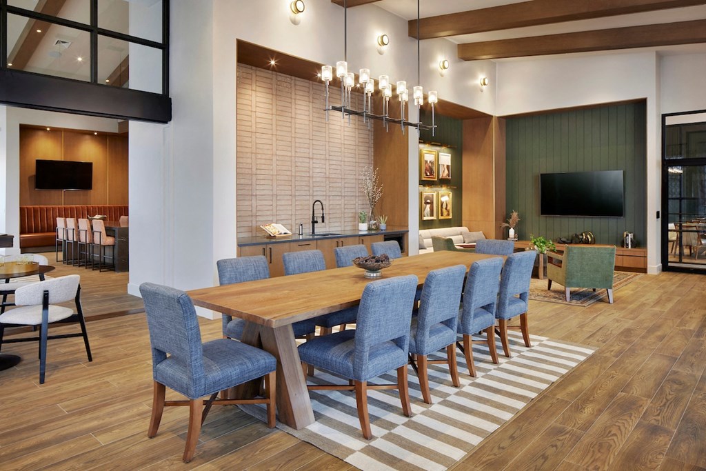 a dining room with a long wooden table and blue chairs