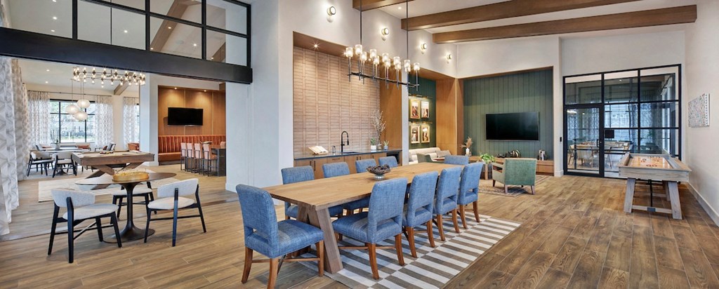 a dining room and living room area with a large wooden table and blue chairs