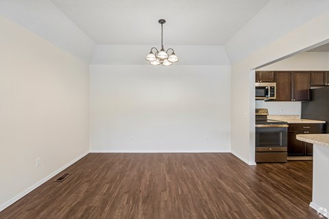 A room with wooden floors and a chandelier hanging from the ceiling.