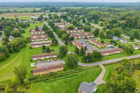 A bird's eye view of a residential area with houses and green lawns.