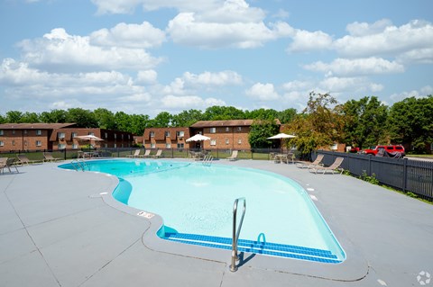 A large swimming pool with a diving board in the middle.