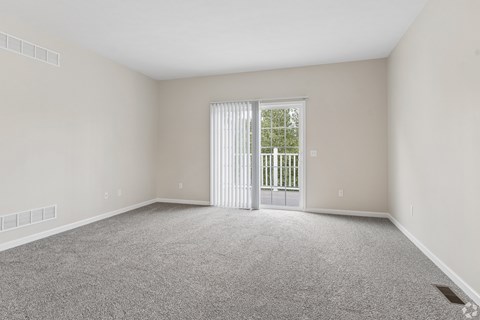 A room with a carpeted floor and a sliding glass door.