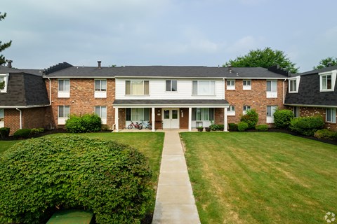 A large brick building with a green lawn in front.