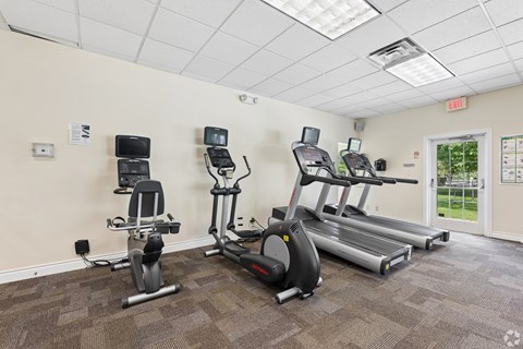 A gym with treadmills, elliptical machines, and stationary bikes.