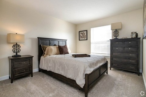 a bedroom with a bed and two dressers