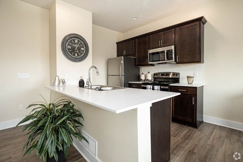 a kitchen with a white counter top and a refrigerator