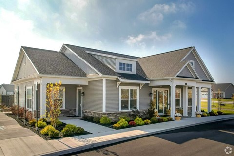 a large house with a driveway and a cloudy sky