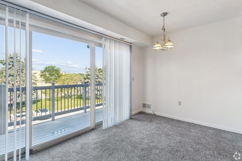 A room with a sliding glass door leading to a balcony.