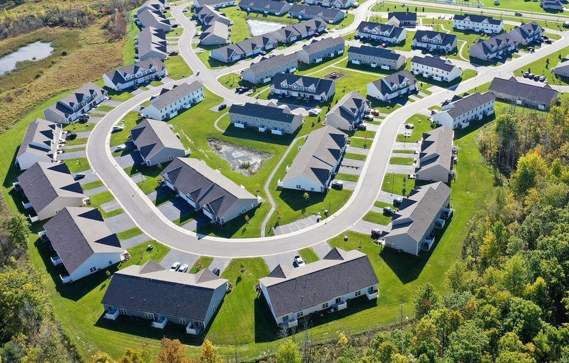 an aerial view of a neighborhood of houses with cars parked