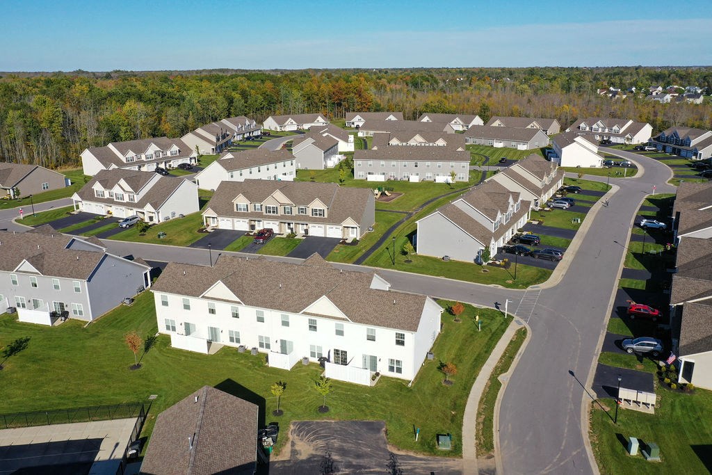 an aerial view of a neighborhood with white houses and gray roofs