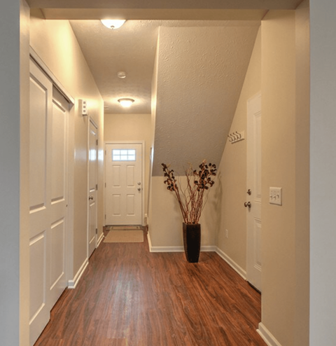 A hallway with a vase of flowers on the right.