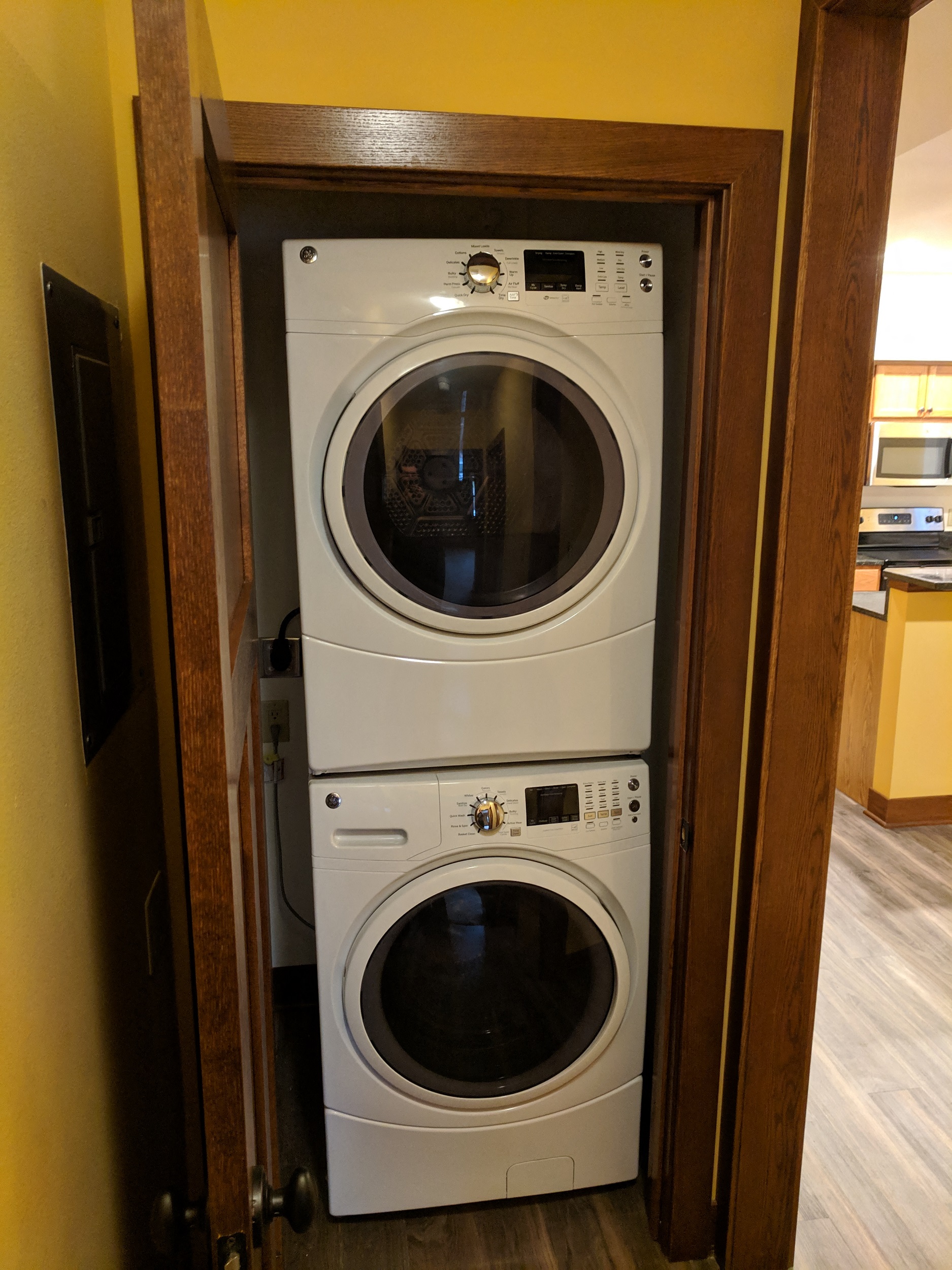 A white front loading washing machine is in a wooden door.