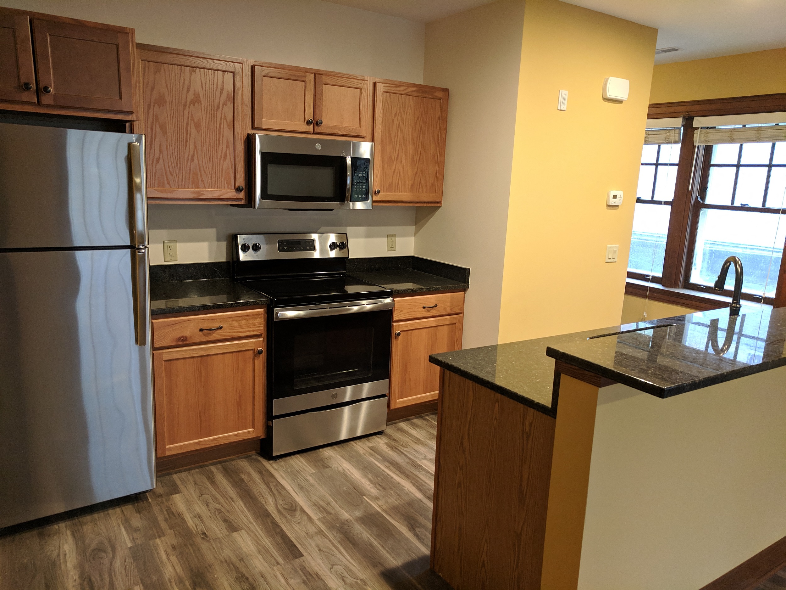 A kitchen with wooden cabinets and a black countertop.
